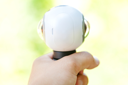 Close up picture of a 360 degree panoramic virtual tour camera in human hand outdoorの写真素材