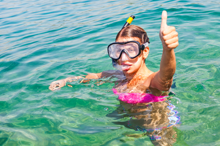 Young woman doing snorkeling in Trogir Croatia, in the clear turquoise water, showing thumbs upの写真素材