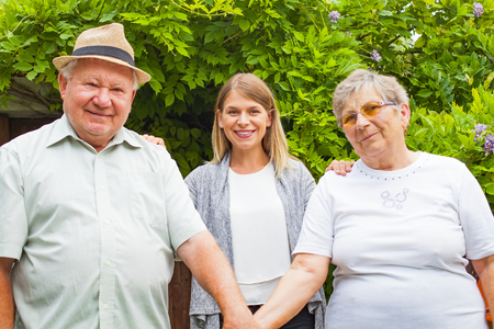 Elderly couple with smiling young granddaughter spending quality time in the parkの写真素材