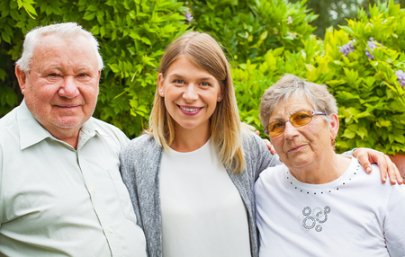 Elderly couple with smiling young granddaughter spending quality time in the parkの写真素材