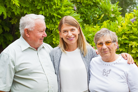 Elderly couple with smiling young granddaughter spending quality time in the parkの写真素材