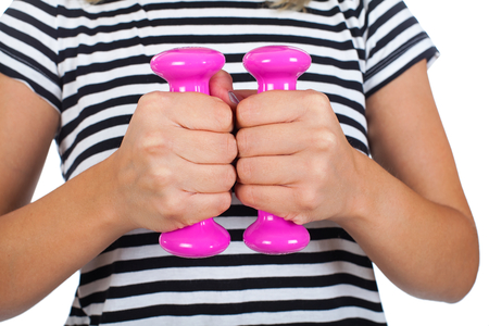 Close up young woman holding pink dumbells on isolated backgroundの写真素材