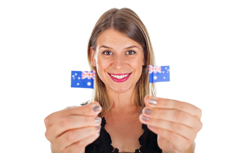 Beautiful australian female holding a mini national flag smiling at the camera on isolatedの写真素材