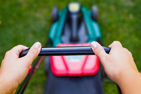 Close up modern lawn mower on the grass in the backyardの写真素材