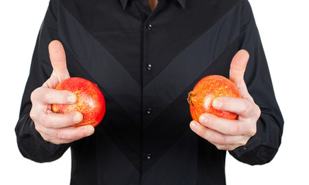 Close up picture of man in black holding ripe pomegranate, high antioxidant fruitの写真素材