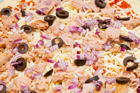 Close up picture of homemade pizza with tuna fish, onions and black olivesの写真素材