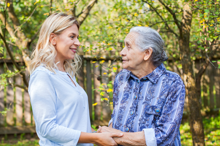 Friendly caregiver walking with old lady in the garden - Medical careの写真素材