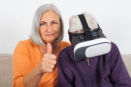 Elderly women experiencing virtual reality video with headsetの写真素材