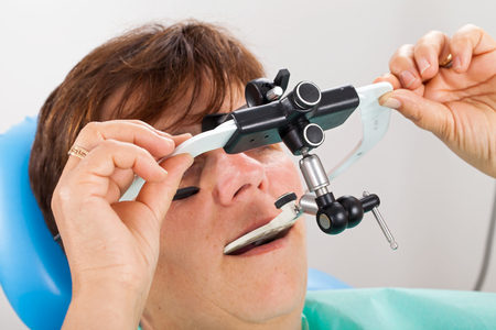 Seniorpatient wearing a  facebow for transfer functional and aesthetic components from patient's mouth to the dental articulatorの写真素材