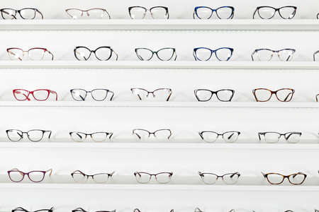 Fashionable corrective eye glasses on a shelf in optical storeの写真素材