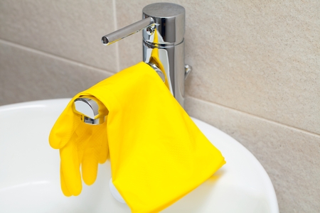 Close up picture of yellow rubber gloves ang brush for cleaning. Bathroom cleaning concept.の写真素材
