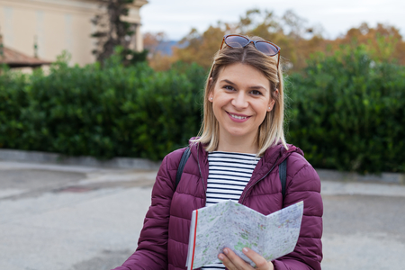 Charming female tourist searching for the right direction in the city map in Barcelona, Cataloniaの写真素材