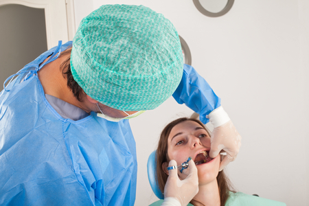 Close up picture of woman at the dentist office receiving local anesthesia before dental procedureの写真素材