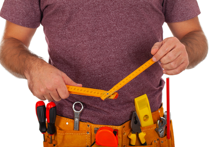 Close up picture of young carpenter with yellow tool belt, maintenance equipment on isolated backgroundの写真素材