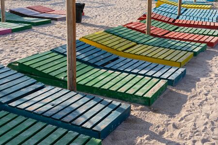Colorful wooden sunbeds and  umbrellas at Vama Veche beachfront, Romania, Black Sea