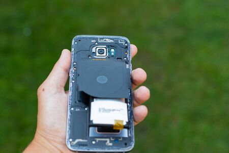 Close up of a damaged smartphone with expanded lithium ion batteryの写真素材