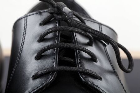 Close up picture of mens footwear. Black leather elegant shoes on grey backgroundの写真素材