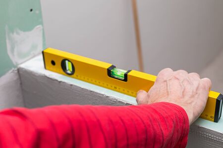 Picture of a worker holding a leveling tool  in a new apartment