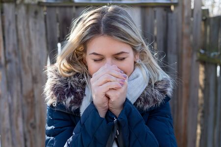 Portrait of a beautiful young lady looking to the camera outdoor on a sunny winter dayの写真素材
