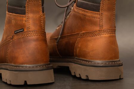 Brand new brown winter boots on gray background