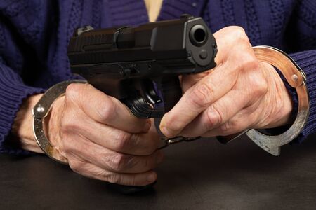 Close up photo of a handcuffed elderly woman