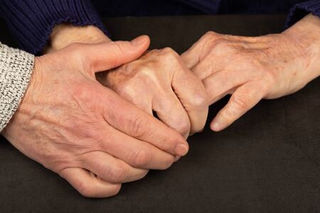 Caregiver touching elderly patients hand at homeの写真素材