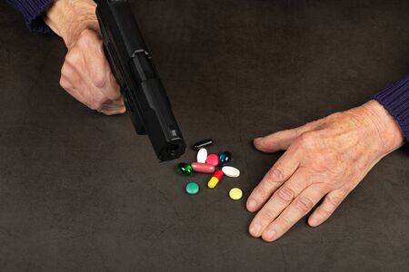 Depressed elderly woman holding a gun in her hands