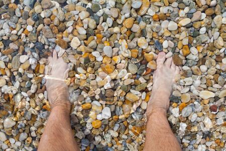 Bare feet at the seaside on summertime, sandy beachの写真素材