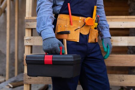 Close up picture of carpenters tool belt and work instruments on wooden backgroundの写真素材
