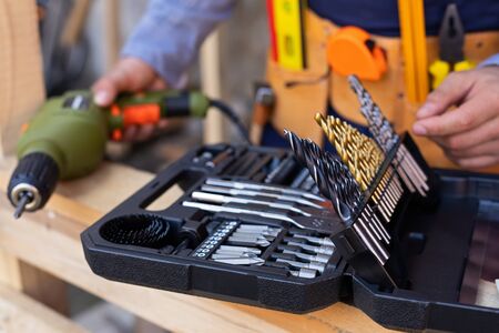 Close up picture of carpenters tool belt and work instruments on wooden background