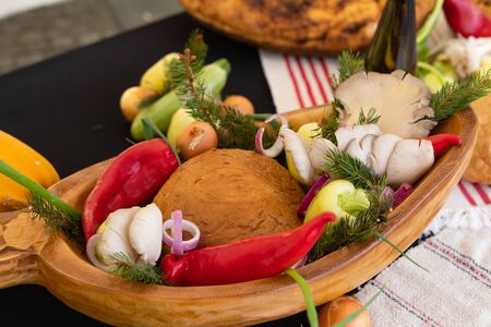 Traditional food from Transylvania - pork bacon, smoked meat with onion, paprika and homemade break on a wooden plateの写真素材