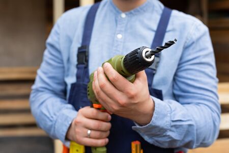 Close up picture of construction worker holding electric drill, renovation at home