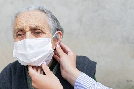 Portrait of elderly woman with chronic disease wearing protective mask because of covid-19 pandemicの写真素材