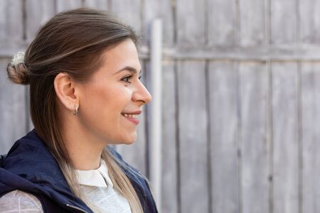 Side portrait of a cheerful caucasian woman smiling