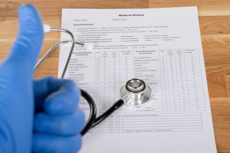 Medical record of sick patient and stethoscope on wooden tableの写真素材
