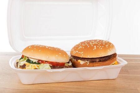 Delicious hamburger in a white plastic delivery box on wooden tableの写真素材