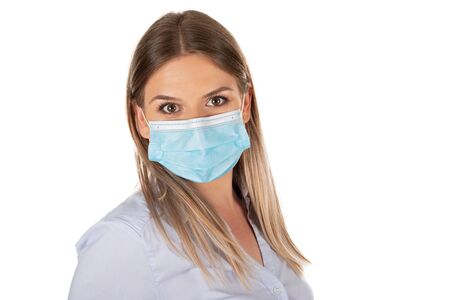 Beautiful caucasian woman wearing protective face mask , posing on isolated backgroundの写真素材