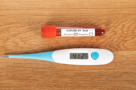 Close up picture of covid-19 blood test and medical supplies, pills on wooden background