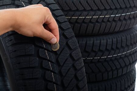 Close up picture of black new car tyre and mechanic's hand next to 