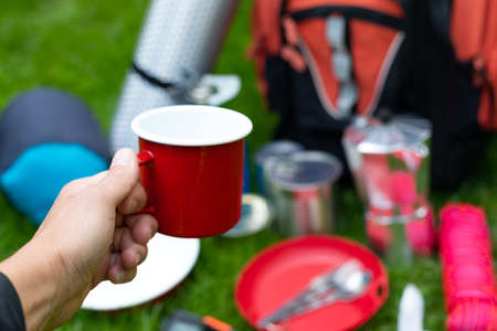 Picture of camping tools on the grass - backpack, tent, gas tank, cans, compass, etc - ready to go in the woodsの写真素材