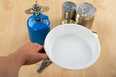 Picture of camping tools on a table -  gas tank, cans, etc - ready to go in the woods