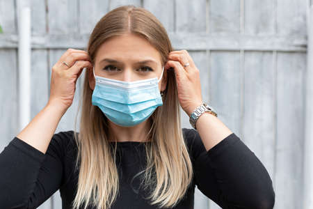 Young caucasian woman with surgical mask outdoor - covid-19 quarantine