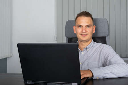 Handsome young businessman sitting in his office