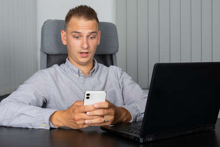 Handsome young businessman talking on the phone at office