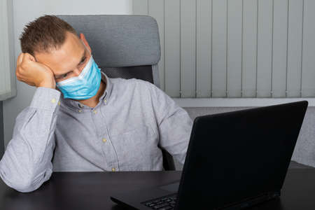 Handsome young businessman sitting in his home officeの写真素材