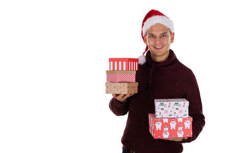 Young caucasian man with Santa hat is holding christmas gifts on isolated background