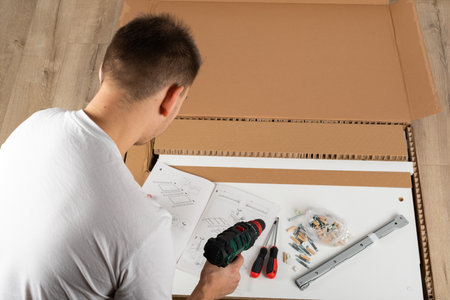 Young man assembling new furniture at home