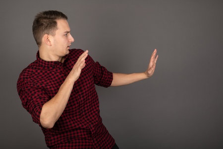 Handsome young entrepreneur posing in front of grey background
