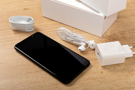 Picture of new smartphone unboxing in front of wooden backgroundの写真素材