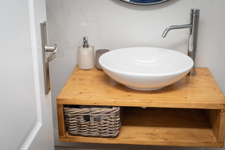 Picture of a renovated stylish bathroom sink on wooden table and stainless steel tap